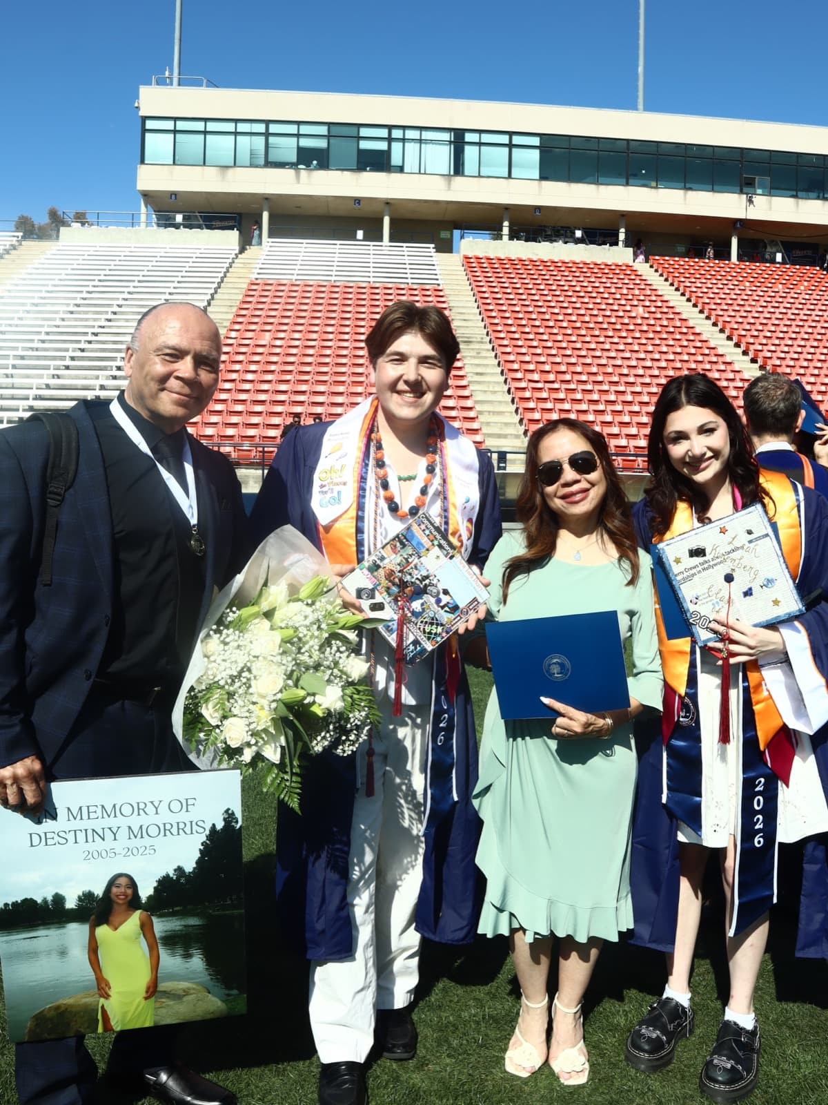 Gregory Ferraro and Leah Korenberg with Destiny Morris’ family after commencement, holding a portrait in her memory.